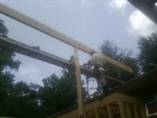 Carpenter setting a ridge beam over a new addition frame — Ice Dam Removal by Roofing Brothers in Pecatonica