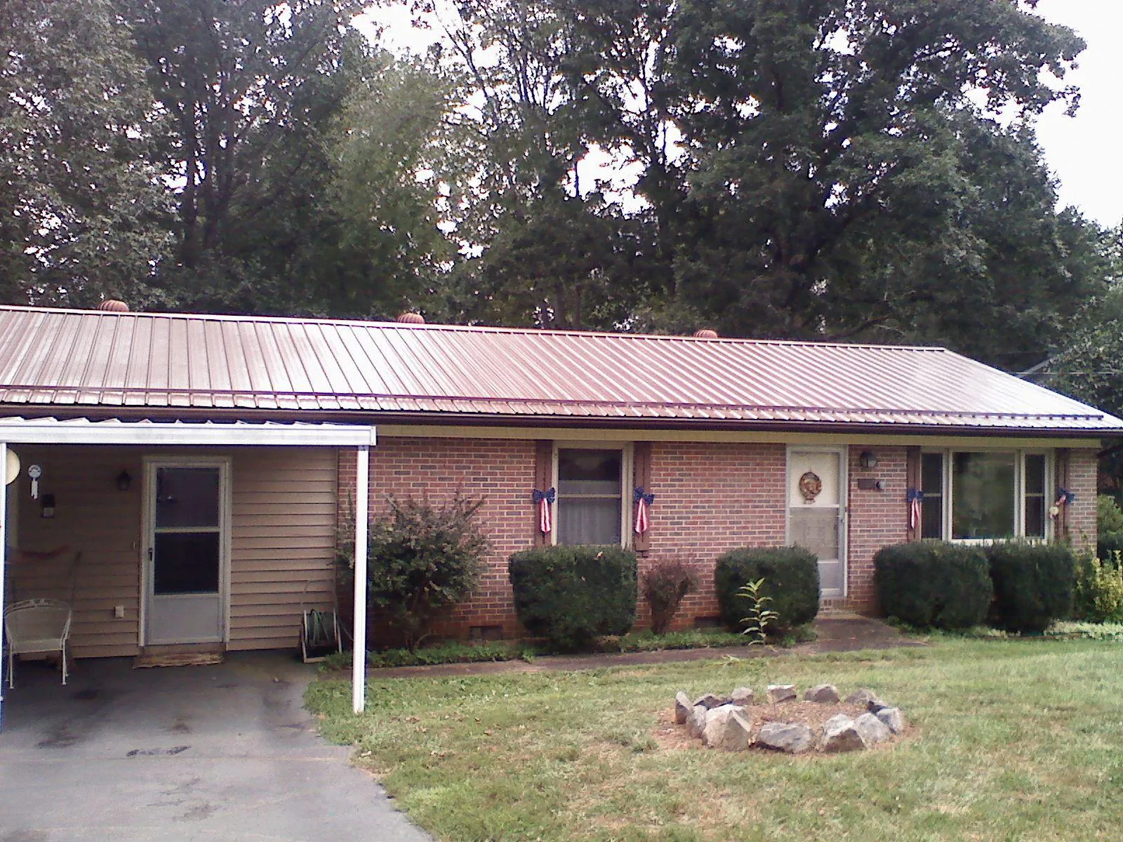 Bronze metal roof and carport on a brick ranch home — Roof Repair work by our crew in Pecatonica